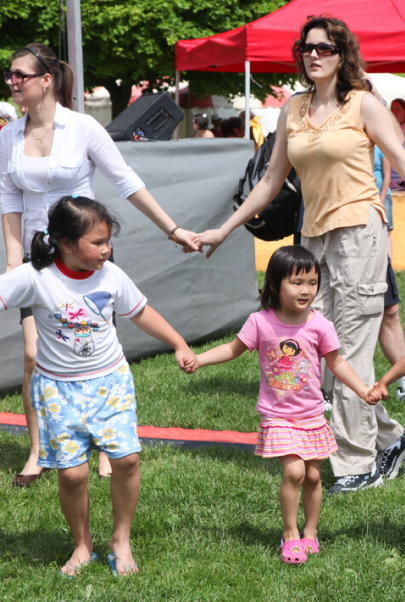 Photo of two women and two children holding hands at an event