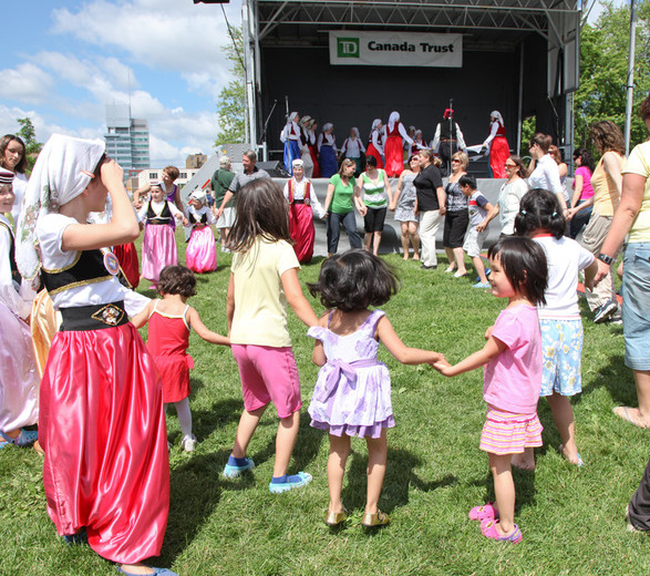 Image of a community festival with adults and children from different cultures holding hands