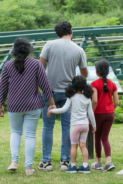 Image of two adults and two children from the back, they appear to be a family